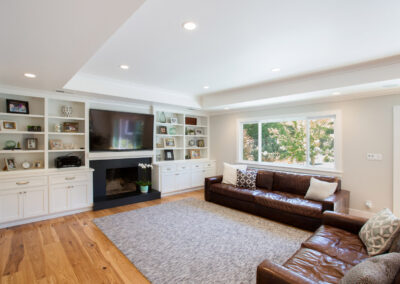 living room with recessed ceiling and build in shelving