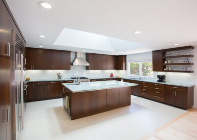 modern style kitchen with dark cabinets and large skylight