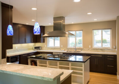 kitchen with hanging pendant lights and range hood over the island