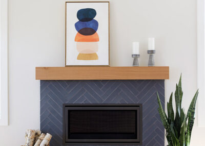 fireplace with navy tile in chevron pattern and modern wood mantle