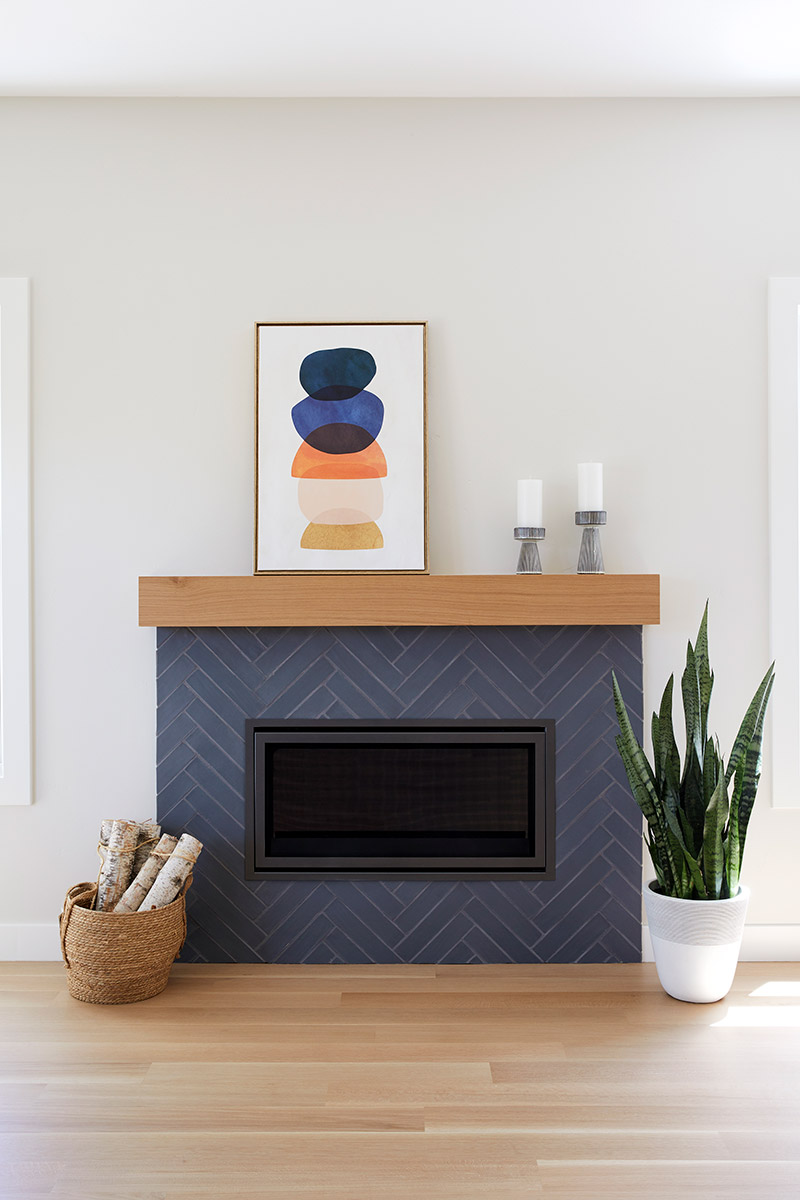 fireplace with navy tile in chevron pattern and modern wood mantle