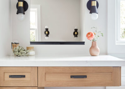 vanity in master bathroom with light wood and white counter