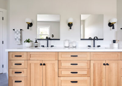 master bathroom with double sink wood vanity and white walls with black fixtures