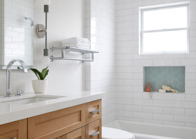 bathroom with white walls and shower tile with blue and teal tile floors