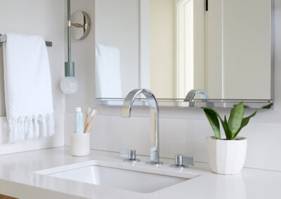 bathroom sink in white countertops and wood vanity