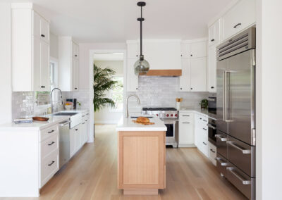 inviting modern kitchen with white cabinets light gray tile backsplash and wood floors