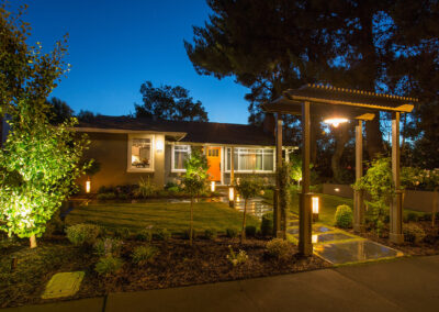 craftsmen style home exterior at night with lighting and excellent landscaping