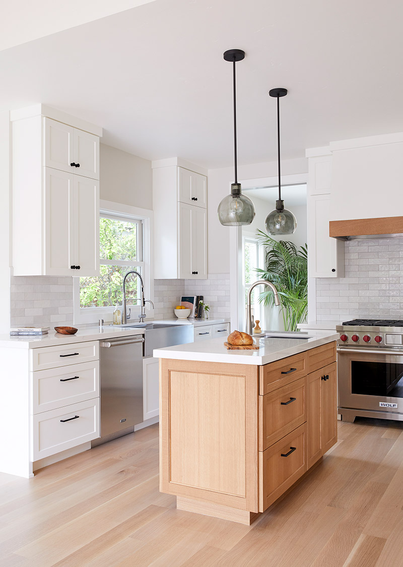 kitchen with light wood floors white cabinets and modern fixtures