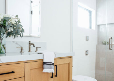 wooden vanity with white marble counter in master bathroom