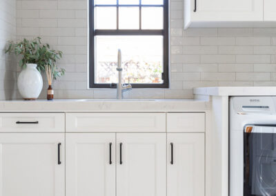 laundry room with sink and counter and white cabinetry