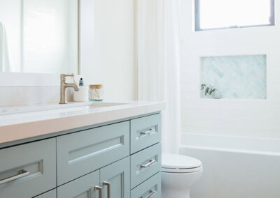 pastel blue bathroom vanity with intricate tile floor and shower