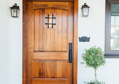 rustic wood front door and brick front porch