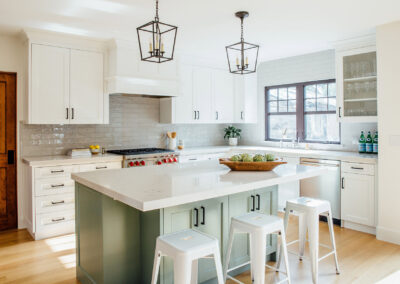 kitchen view from left includes white cabinets and modern rustic pendant light fixtures