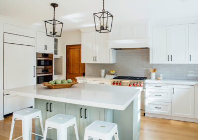 kitchen view from right of green blue kitchen island and white cabinets